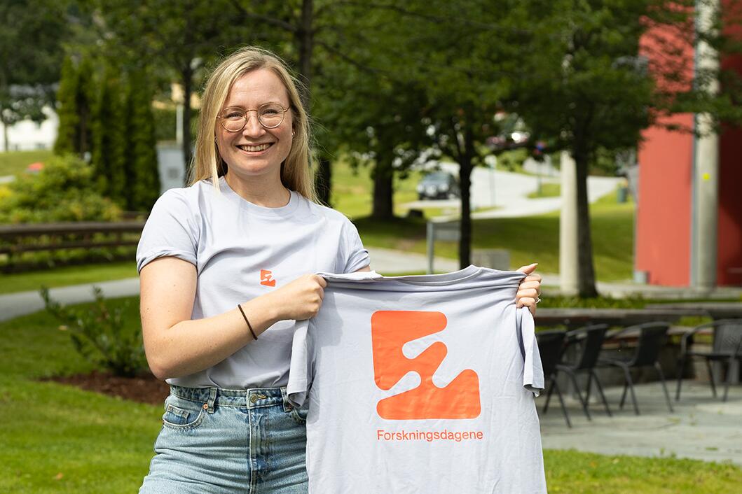 Koordinator Ida Haug Theodorsen viser fram T-skjorta til Forskingsdagane 2023.