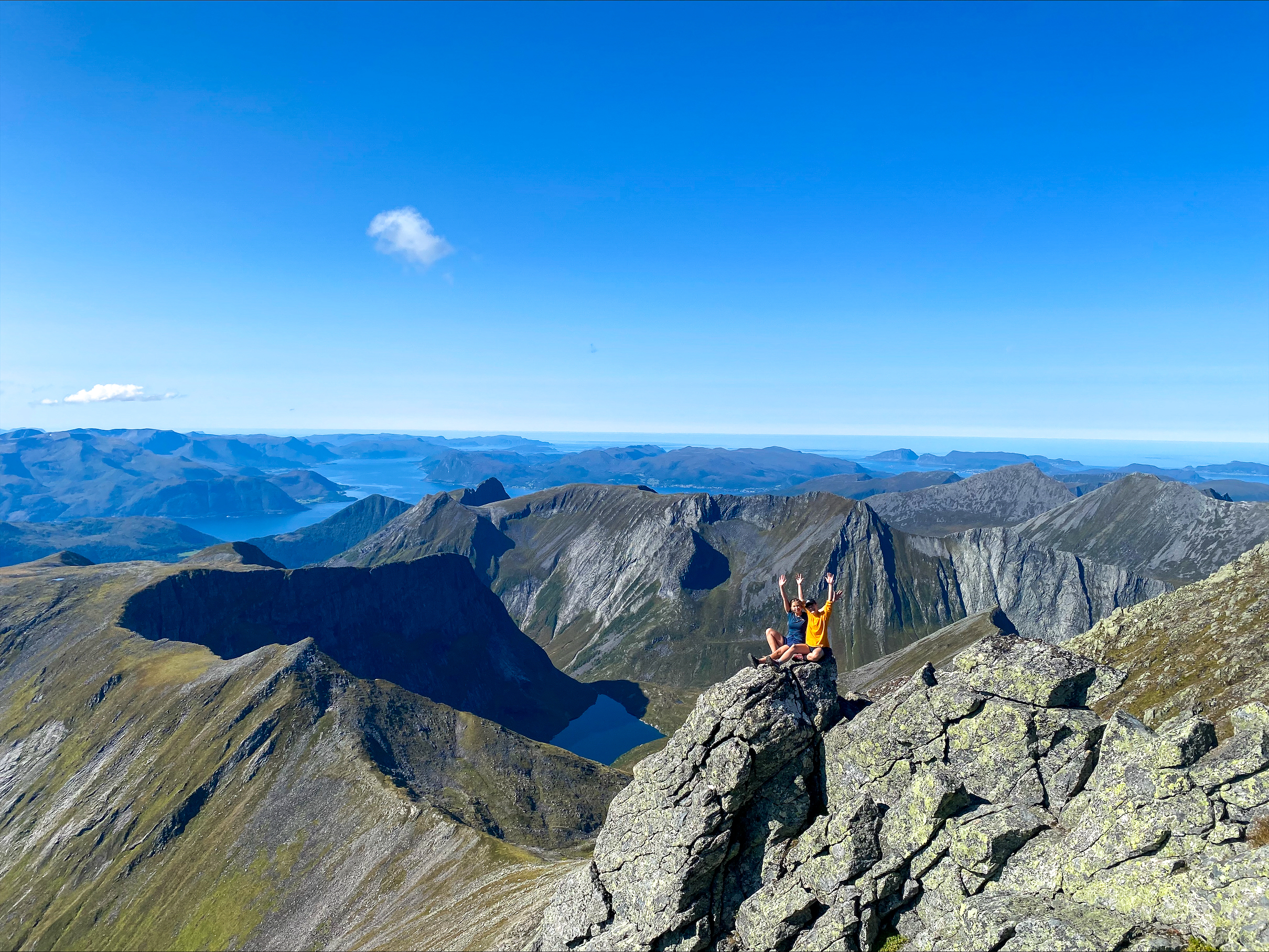 Utsiktsbilde fra fjelltopp med blå himmel.