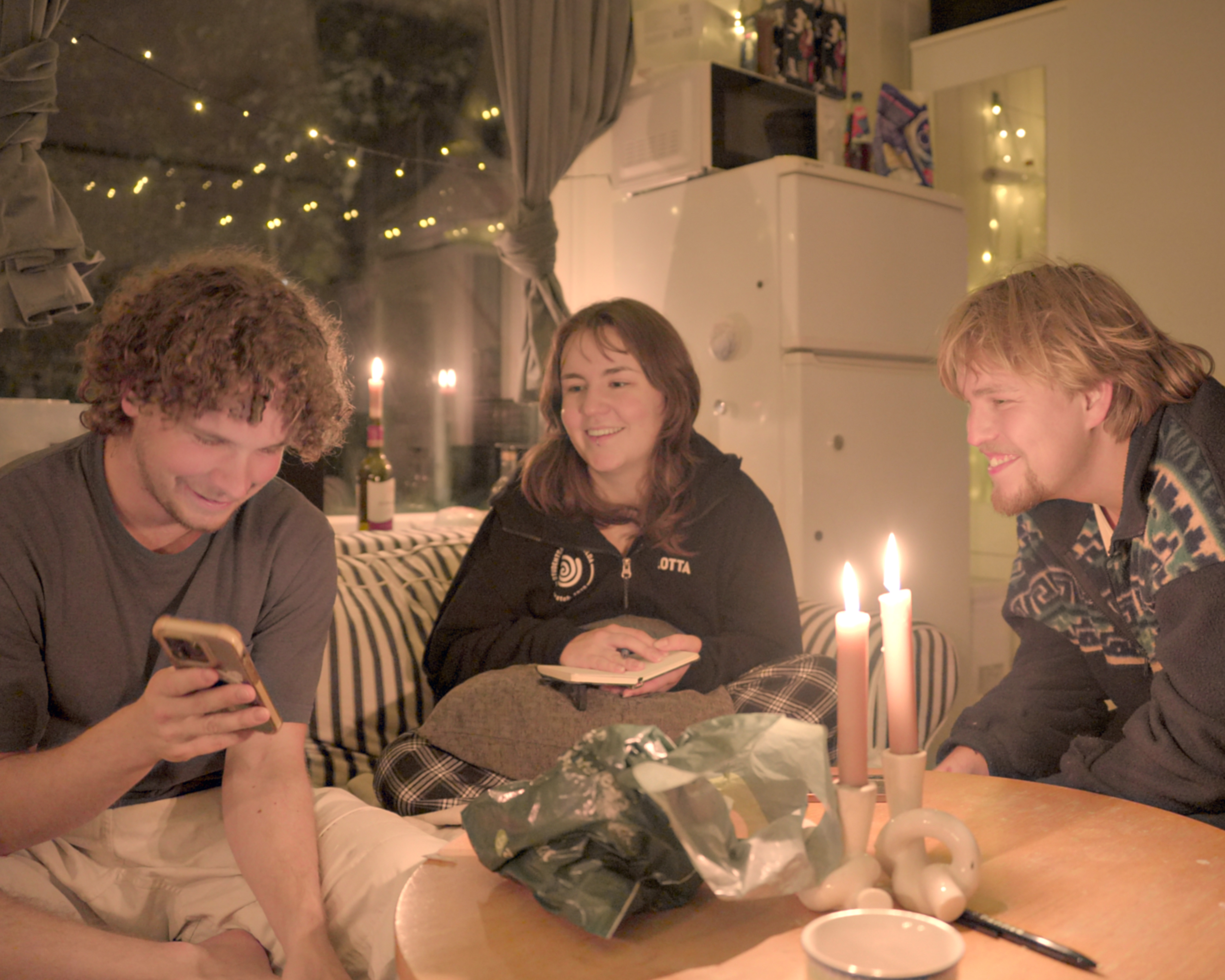 Friends in apartment with lit candles