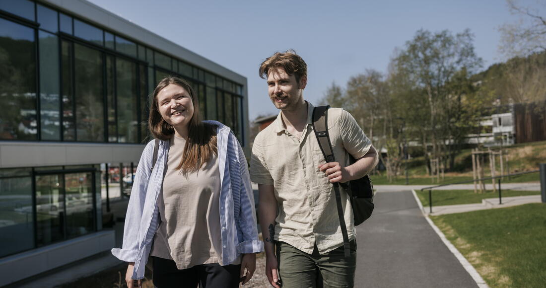 To unge studenter som går ute på campus i sommer og fint vær