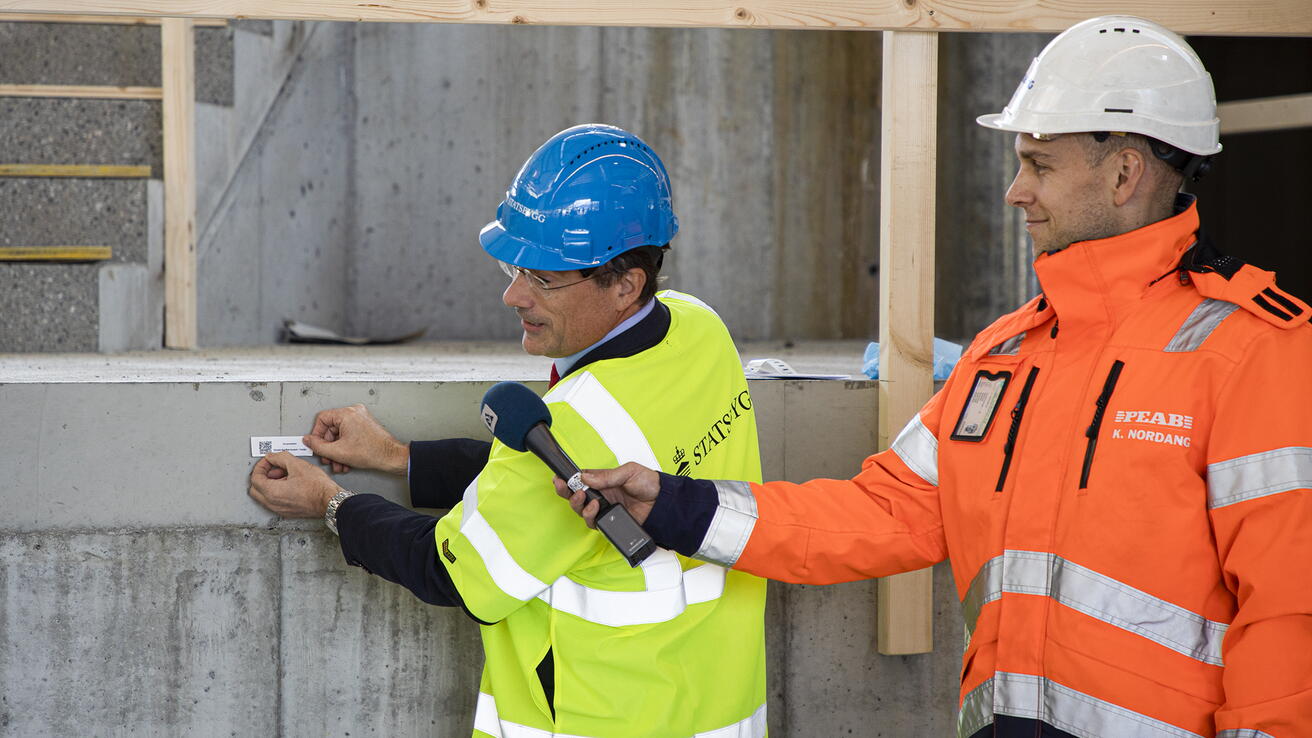 Grunnstein mediebygg 2020 Johan Roppen klistrar opp grunnsteinen til Mediebygget