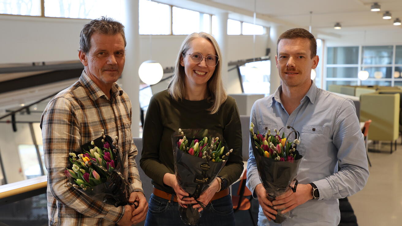 HVO-forskarane Stig J. Helset, Randi Neteland og Tor Arne Haugen får blomar for deltaking i nytt senter for fagspråk.