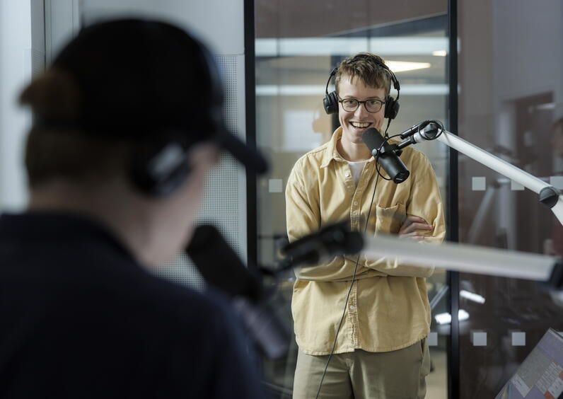 To studenter som øver i et radiostudio